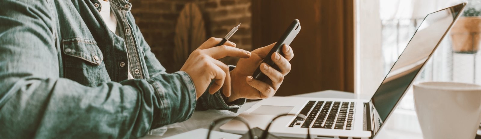 a person working on their laptop and smartphone