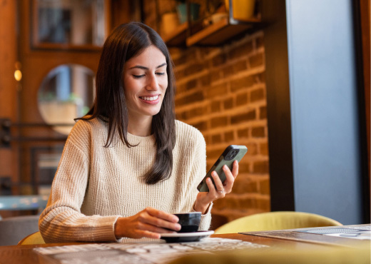 Young woman looking at phone in coffee shop